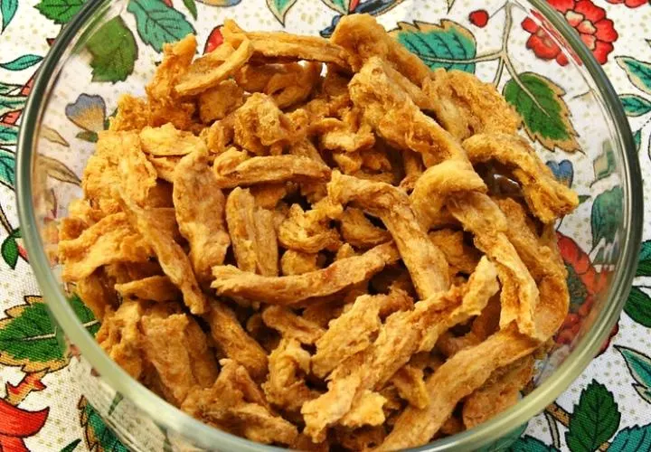 Crisped soy curls tossed in BBQ sauce in a frying pan