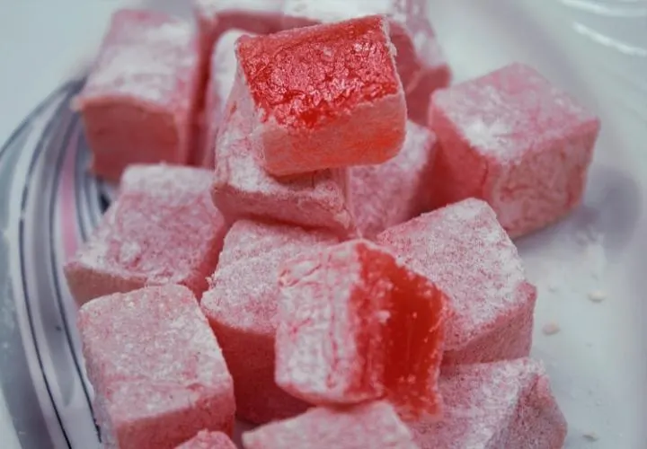 Pink rose Turkish delight cubes dusted with icing sugar in a glass bowl