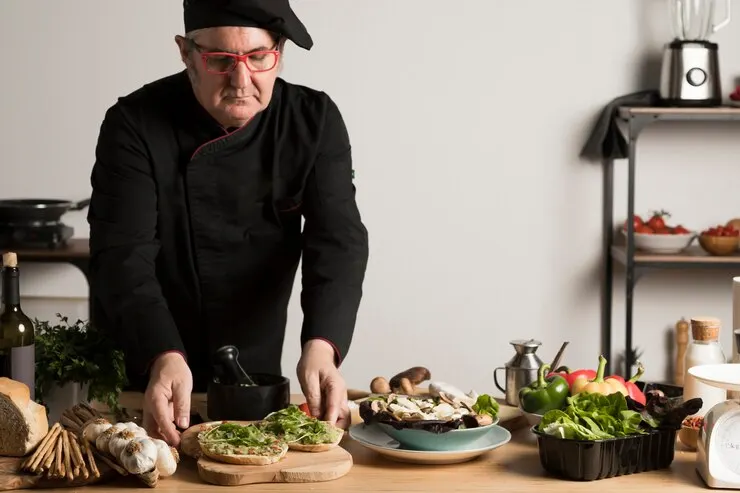 A vegan chef skillfully preparing fresh ingredients in a modern kitchen, showcasing culinary expertise and creativity.